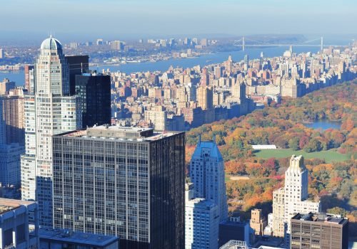 New York City skyscrapers in midtown Manhattan aerial panorama view in the day with Central Park and colorful foliage in Autumn.